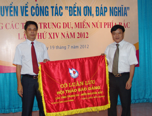 Đồng chí Đinh Văn Ổn, Tổng Biên tập Báo Hòa Bình nhận cờ luân lưu đăng cai hội thảo báo Đảng các tỉnh Trung du, miền núi phía Bắc lần thứ XV.